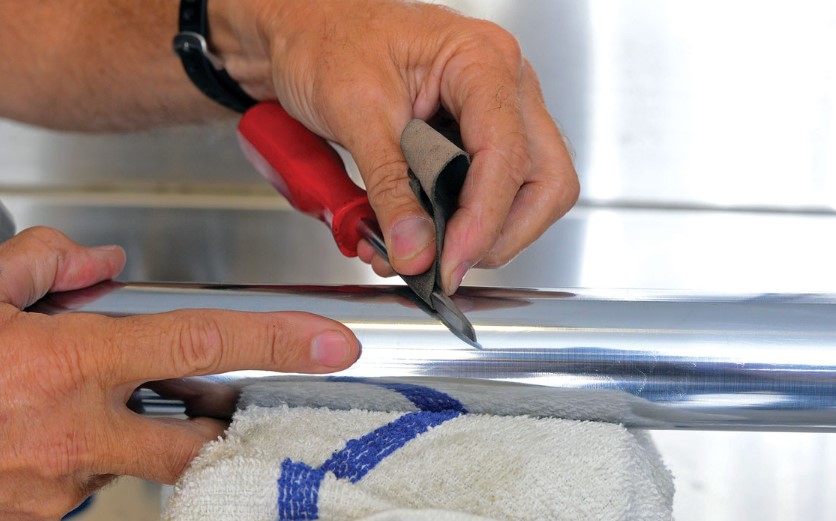 Inspecting a motorcycle fork tube for small scratches and burrs